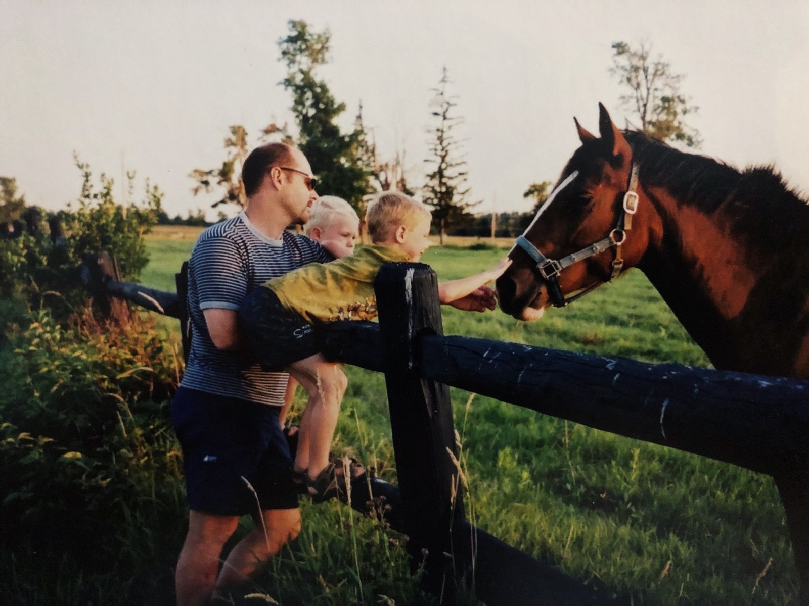Future student veterinarian Salomon with his father and brother petting a horse